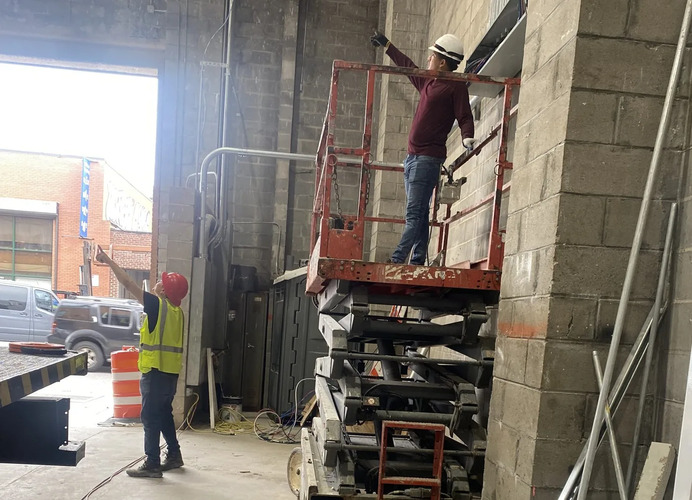 ESS Electric crew working from a scissor lift in a commercial space