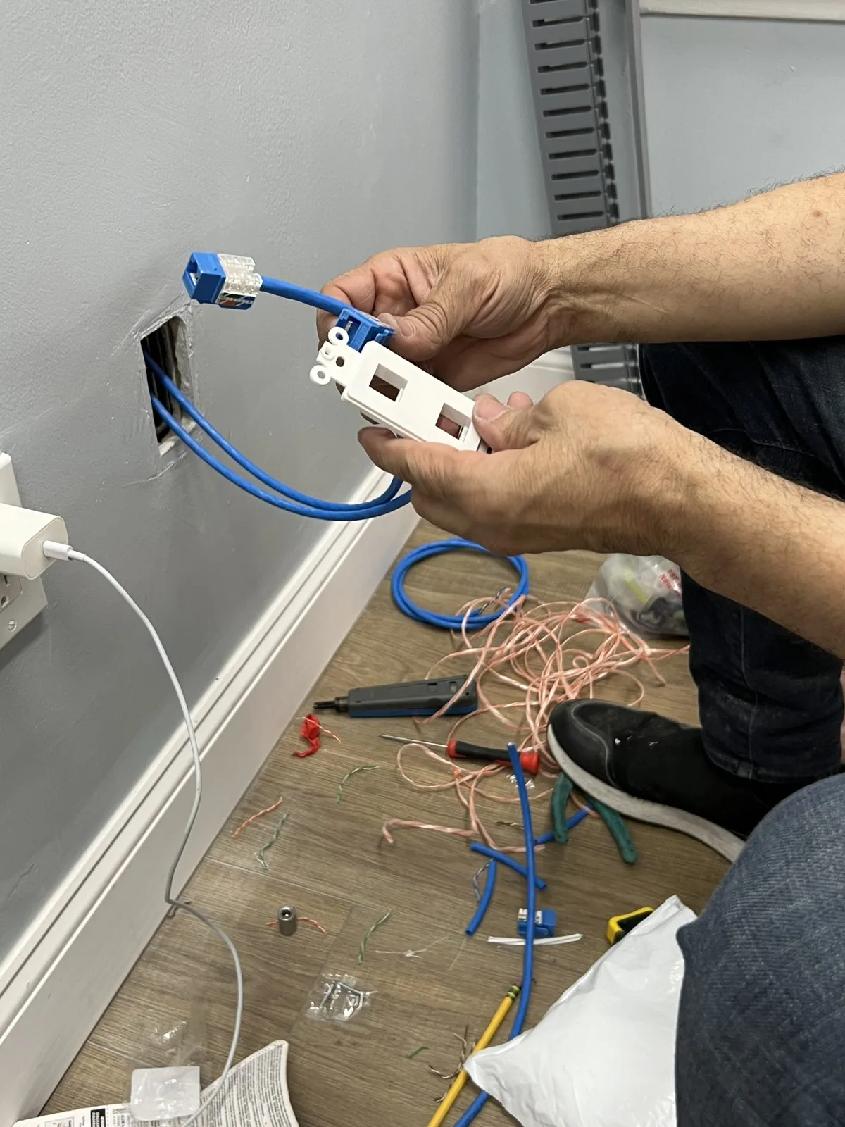 Data cables being connected to a wall-mounted network module